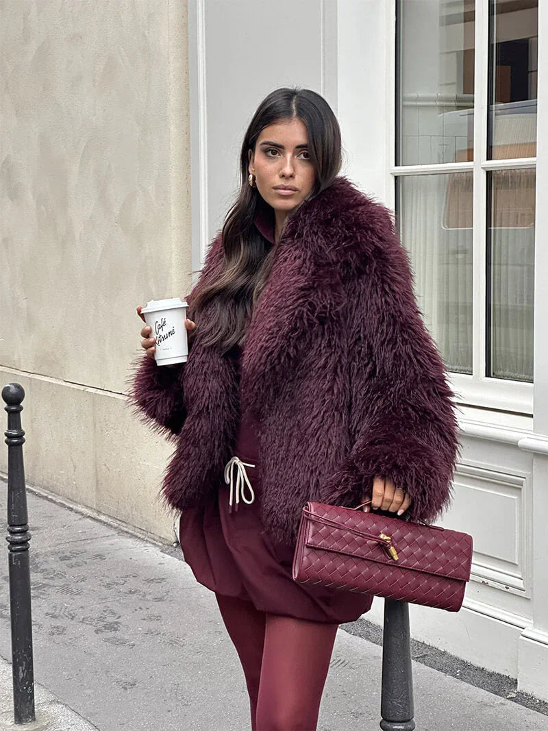 Model wearing a fur jacket while carrying the Alba shoulder bag